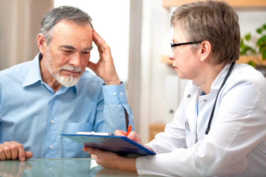 A doctor discusses a dementia care plan with her patient’s caregiver. 