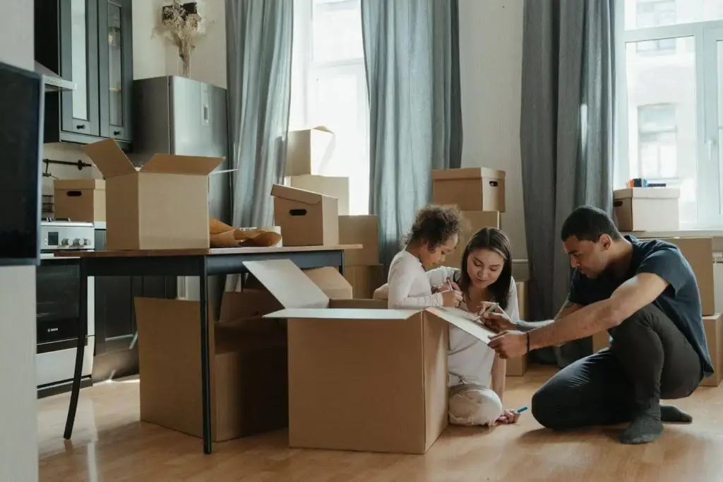 Family sits around looking at memories while packing boxes for their move.