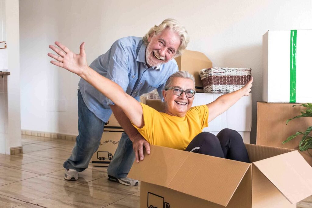 A happy senior couple packs up their home to be sold.