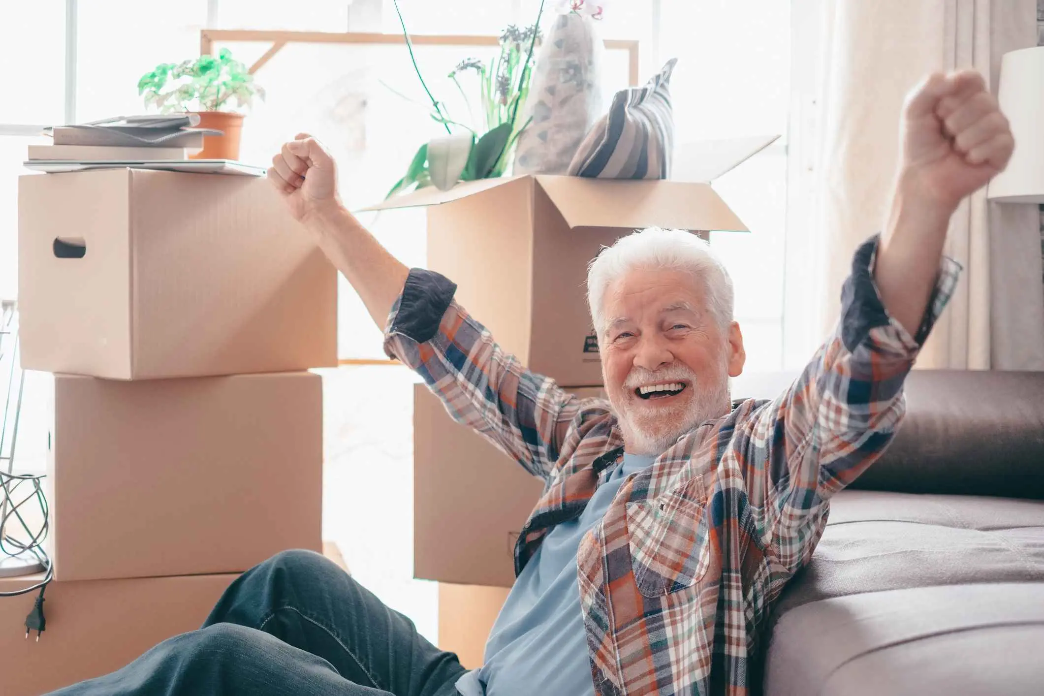 A man smiles as he unpacks in his new home.