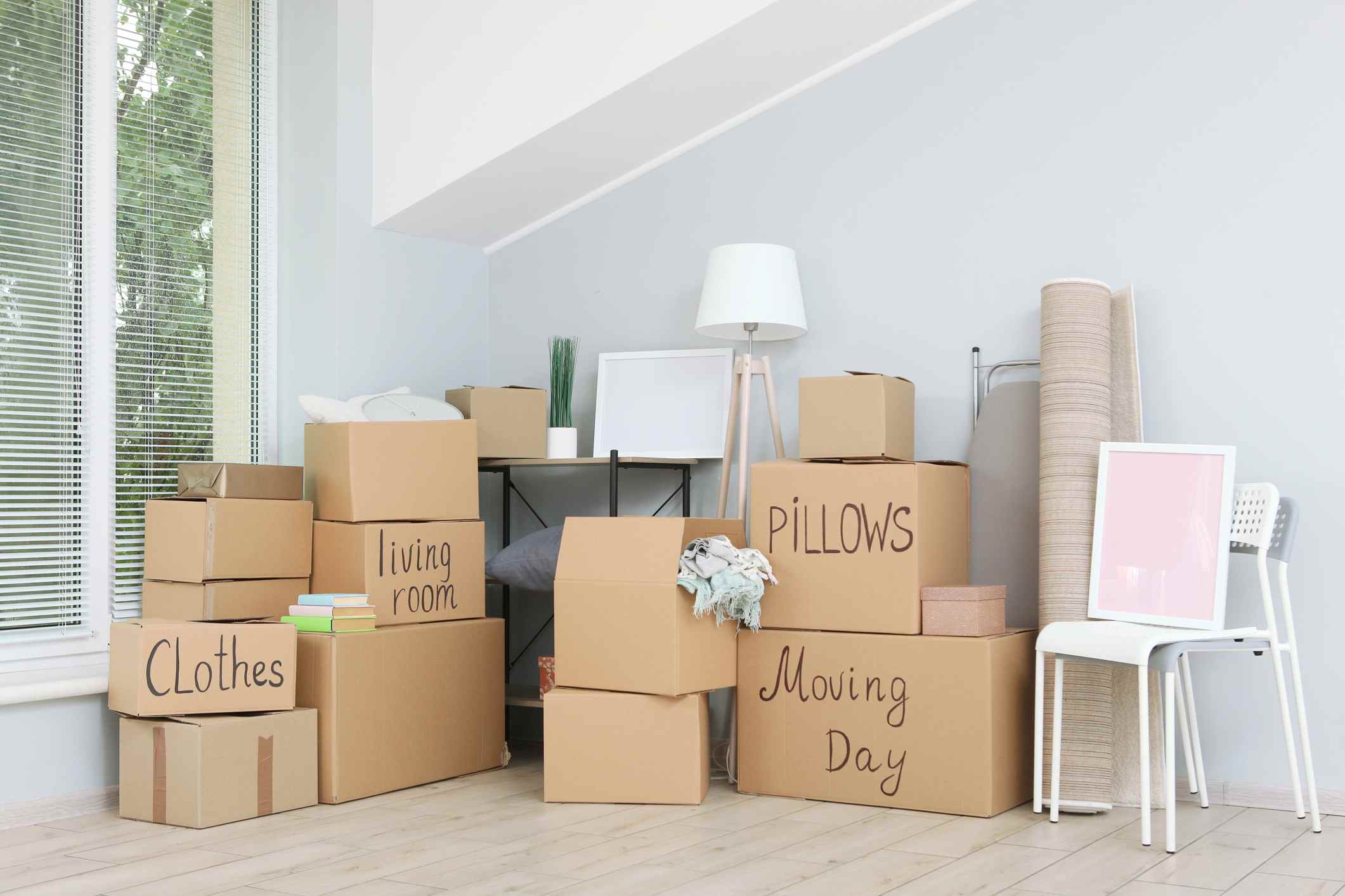 iStock-1257565296 Cardboard boxes and household stuff in empty room. Moving day