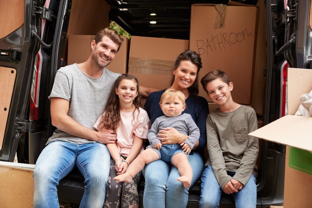 A family sits together in their car before starting their cross-country move.