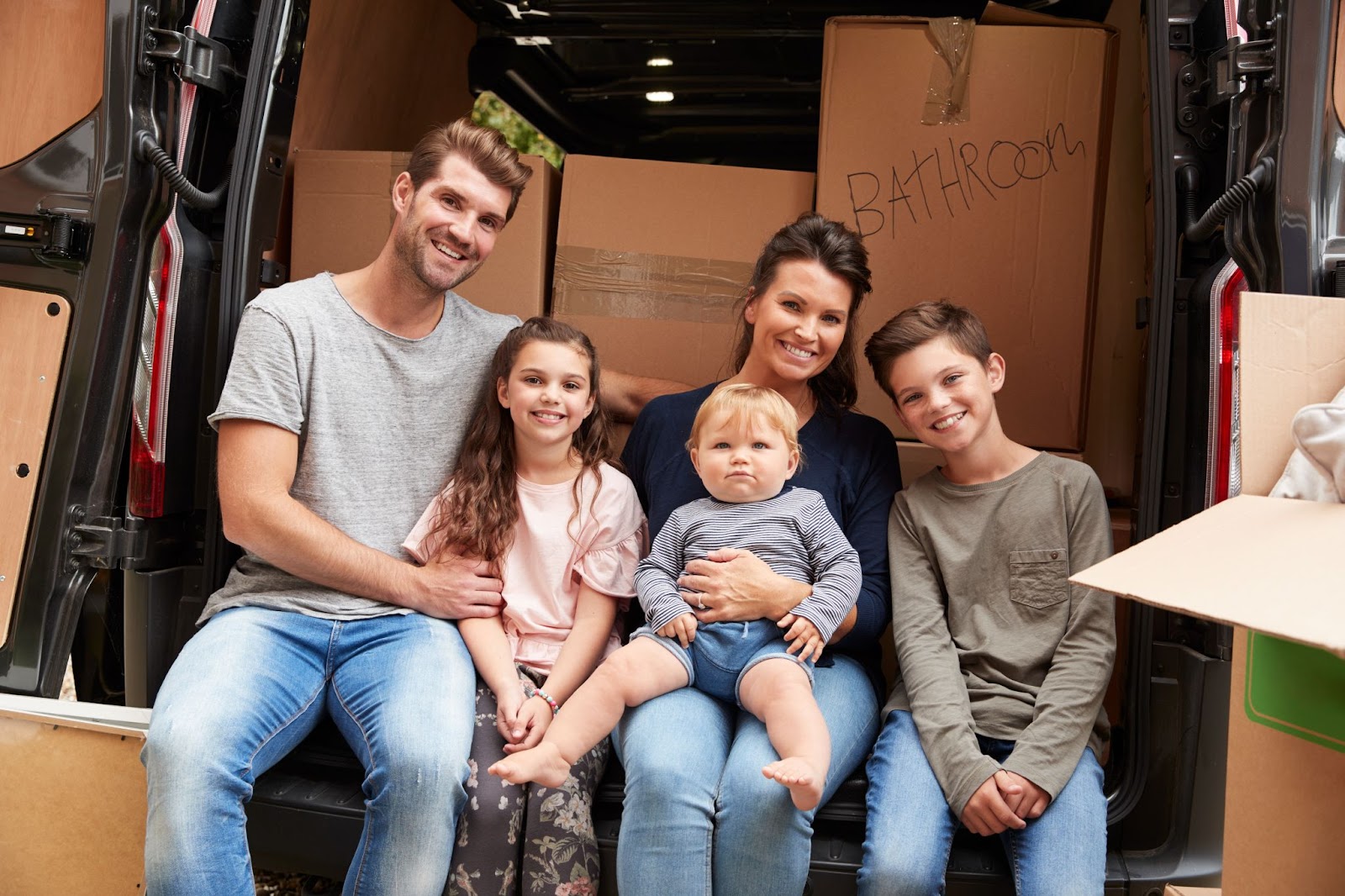A family sits together in their car before starting their cross-country move.