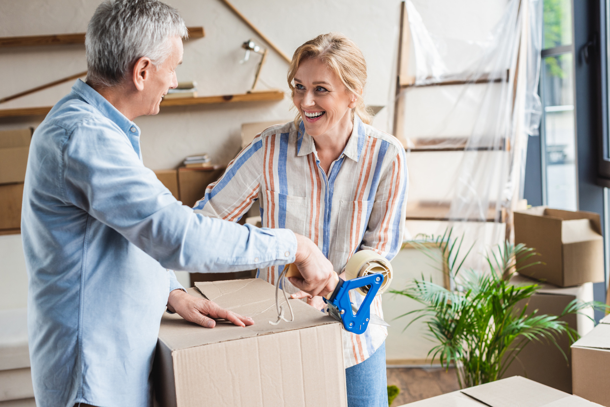 happy elderly couple packing cardboard boxes during relocation happy elderly couple packing cardboard boxes during relocation