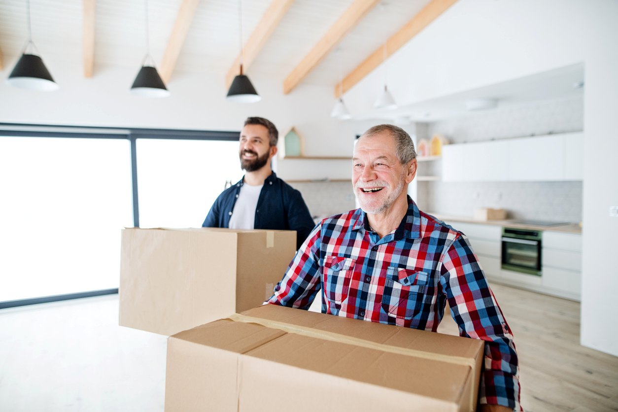 iStock-1135275405 Young man helping an older man move boxes