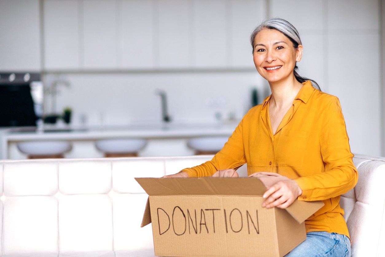 iStock-1301224018 Woman holds a donation box.