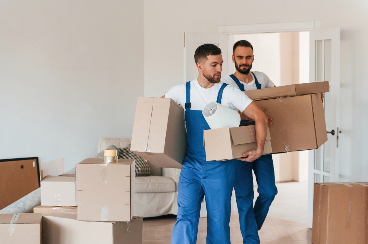 iStock-1834689865 Professional movers carrying boxes out of a room.