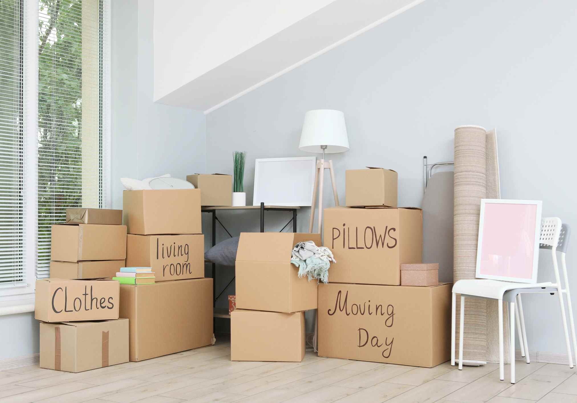iStock-1257565296 Cardboard boxes and household stuff in empty room. Moving day