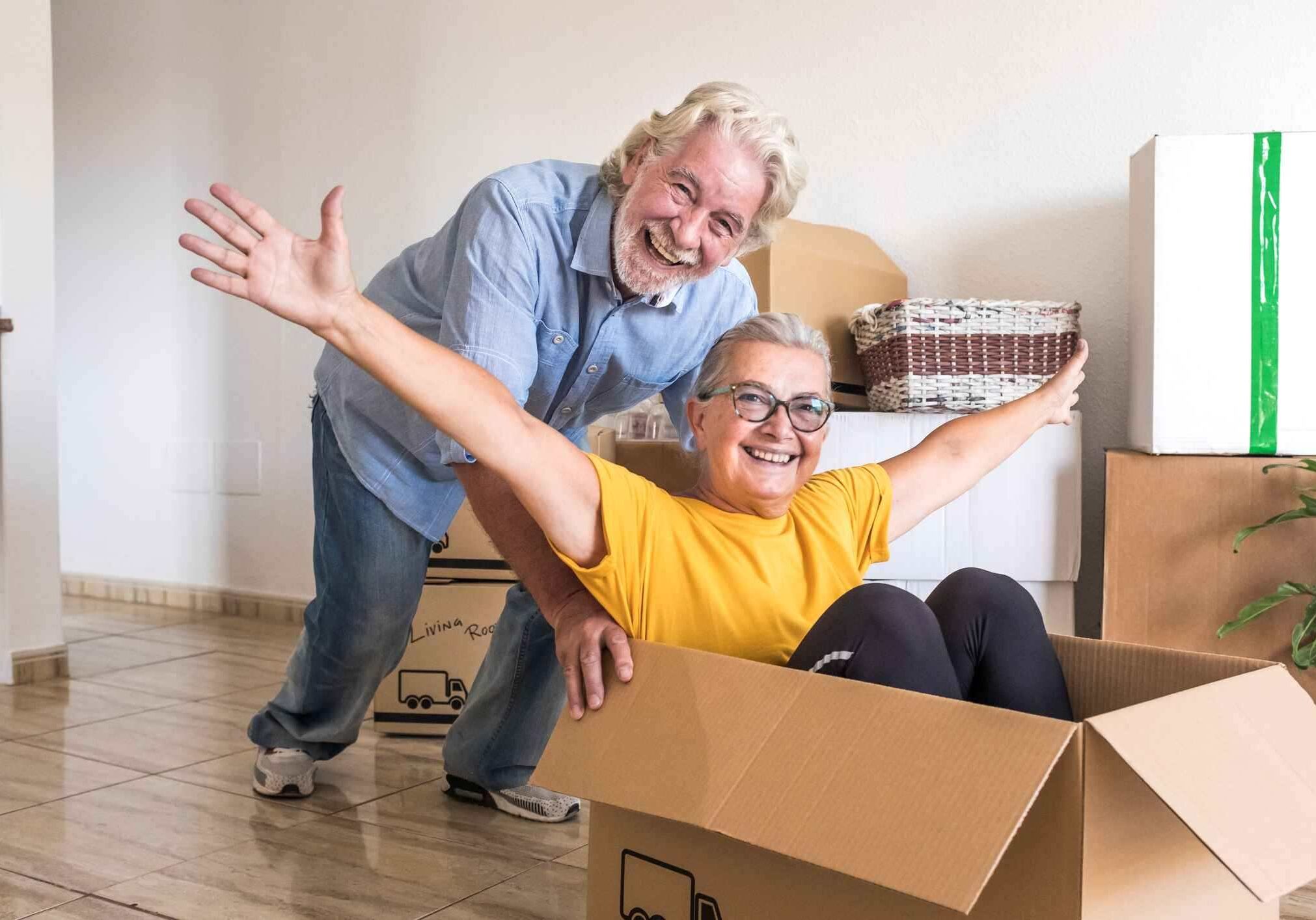 iStock-1271151353 A happy senior couple packs up their home to be sold.