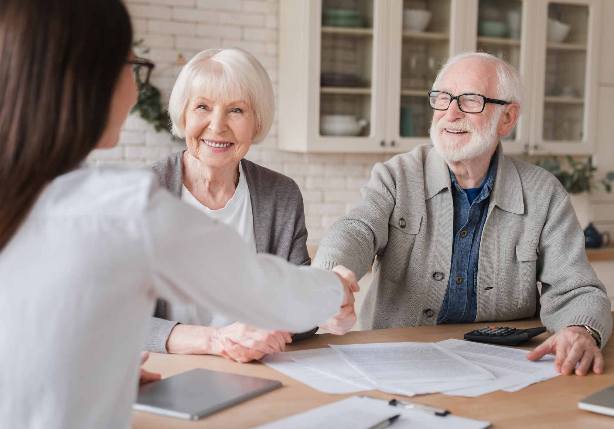 Happy old elderly senior grandparents family couple clients signs financial insurance, pension, startup, dealing handshake agent lawyer, agreement with customers on investment contract, bank manager