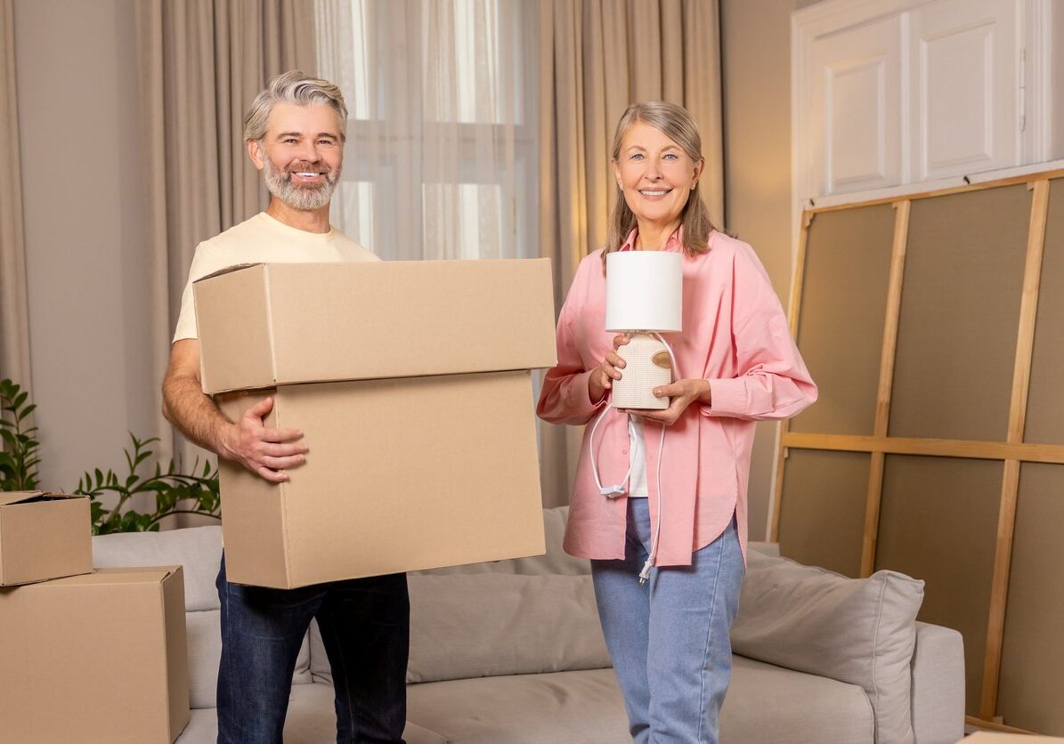iStock-2193908885 Older couple holding boxes and lamps.