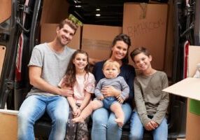 A family sits together in their car before starting their cross-country move.