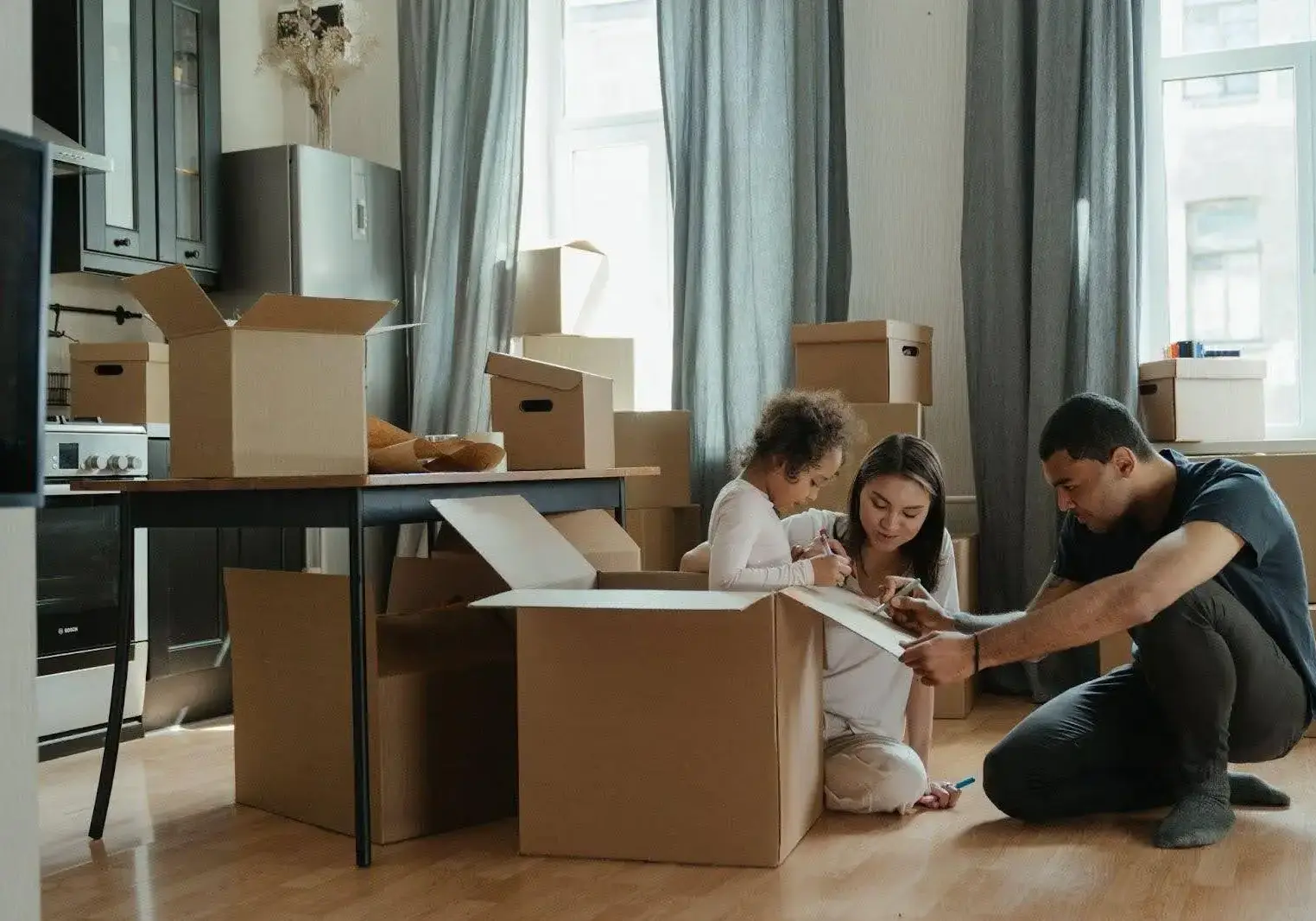 wellrive6 Family sits around looking at memories while packing boxes for their move.
